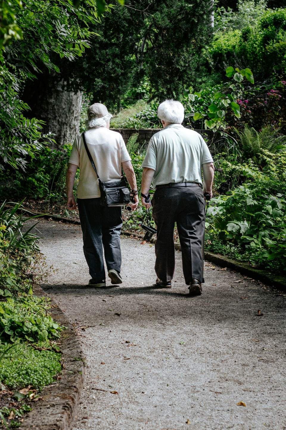 Elderly couple walking together down a path