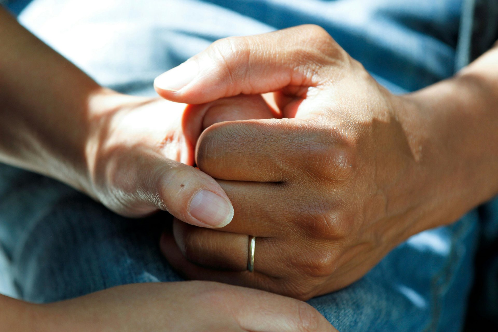 Hands of two individuals holding gently together